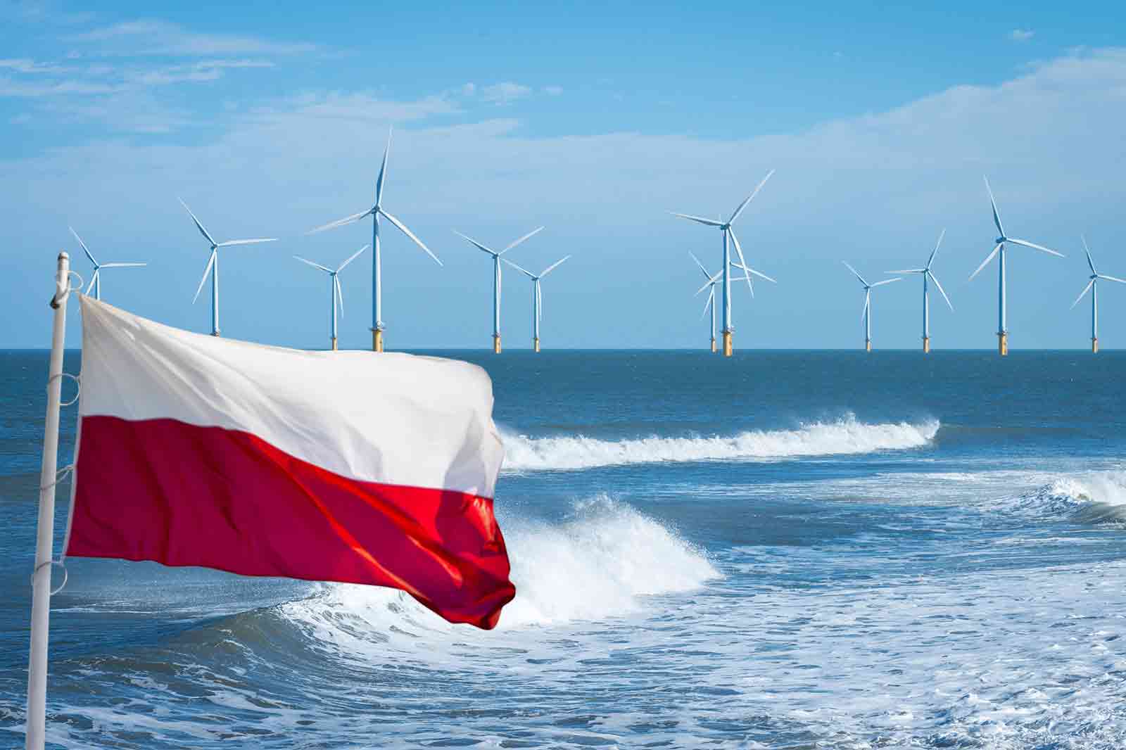 Polska flaga powiewa przed oceanem z elektrowniami wiatrowymi w oddali na tle czystego nieba.